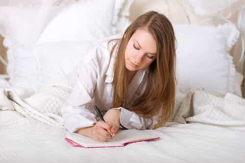 Mujer escribiendo en la cama