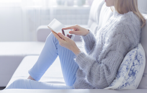 Mujer con la tablet en el sofá