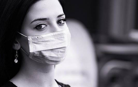 Chica con mascarilla pensando en la responsabilidad individual durante el desconfinamiento