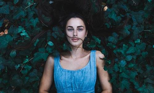 Chica entre hojas pensando en saber reaccionar