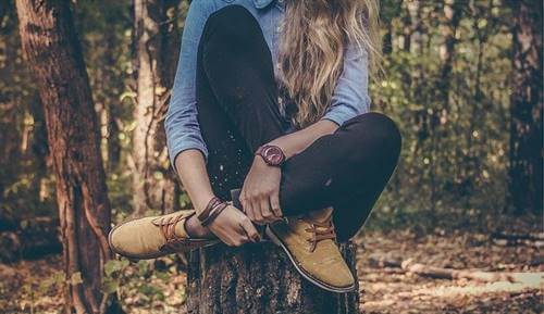 Chica sobre tronco pensando en tu relación contigo