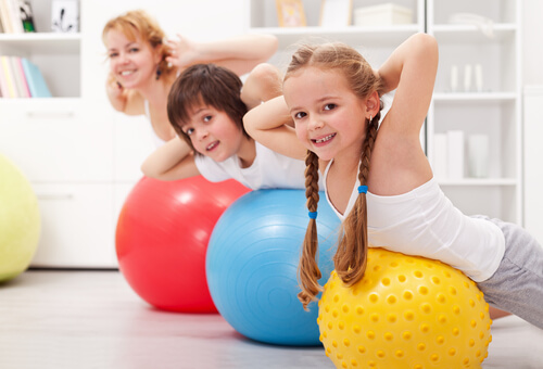 Niños haciendo deporte con su madre en casa