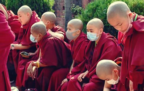 Monjes representando cómo manejan los budistas la crisis del coronavirus