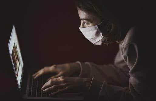 Chica con mascarilla ante ordenador representando el amor en tiempos de pandemia