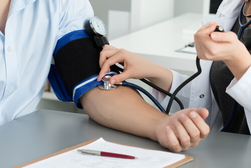 Médico midiendo la tensión arterial