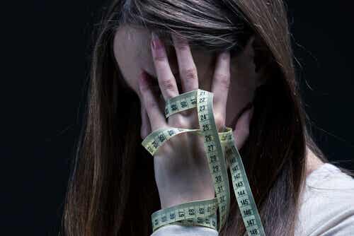 Mujer con anorexia con el metro en la mano