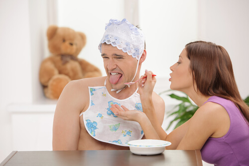 Hombre adulto vestido de bebé rechazando la comida