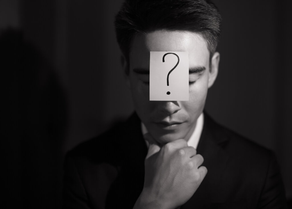 Hombre con un papel en la frente con una interrogación