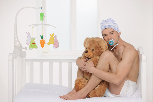 Hombre vestido de bebé abrazando a un oso