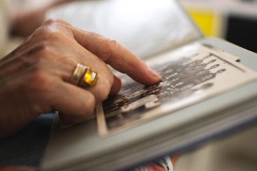 Mujer viendo un album de fotos como rito de despedida