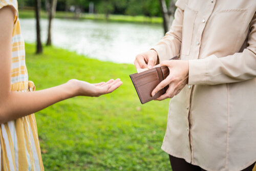 Padre dando dinero a su hija adolescente