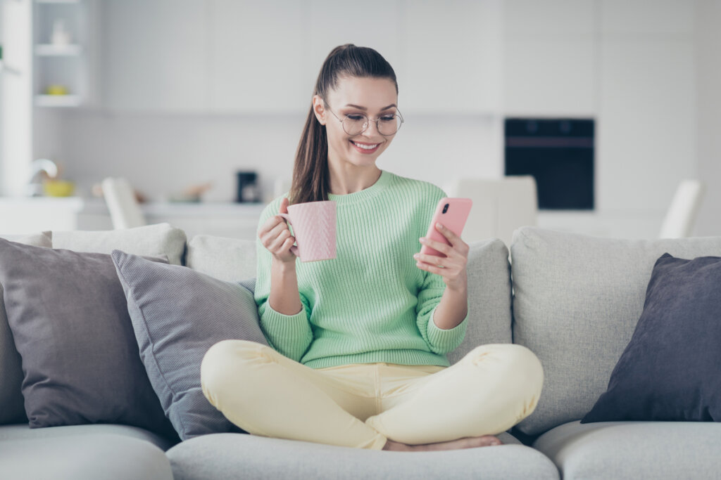 Girl with mobile on the sofa representing the heuristic of attraction