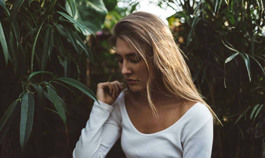 Chica triste en el campo simbolizando que la adversidad no siempre nos hace más resilientes