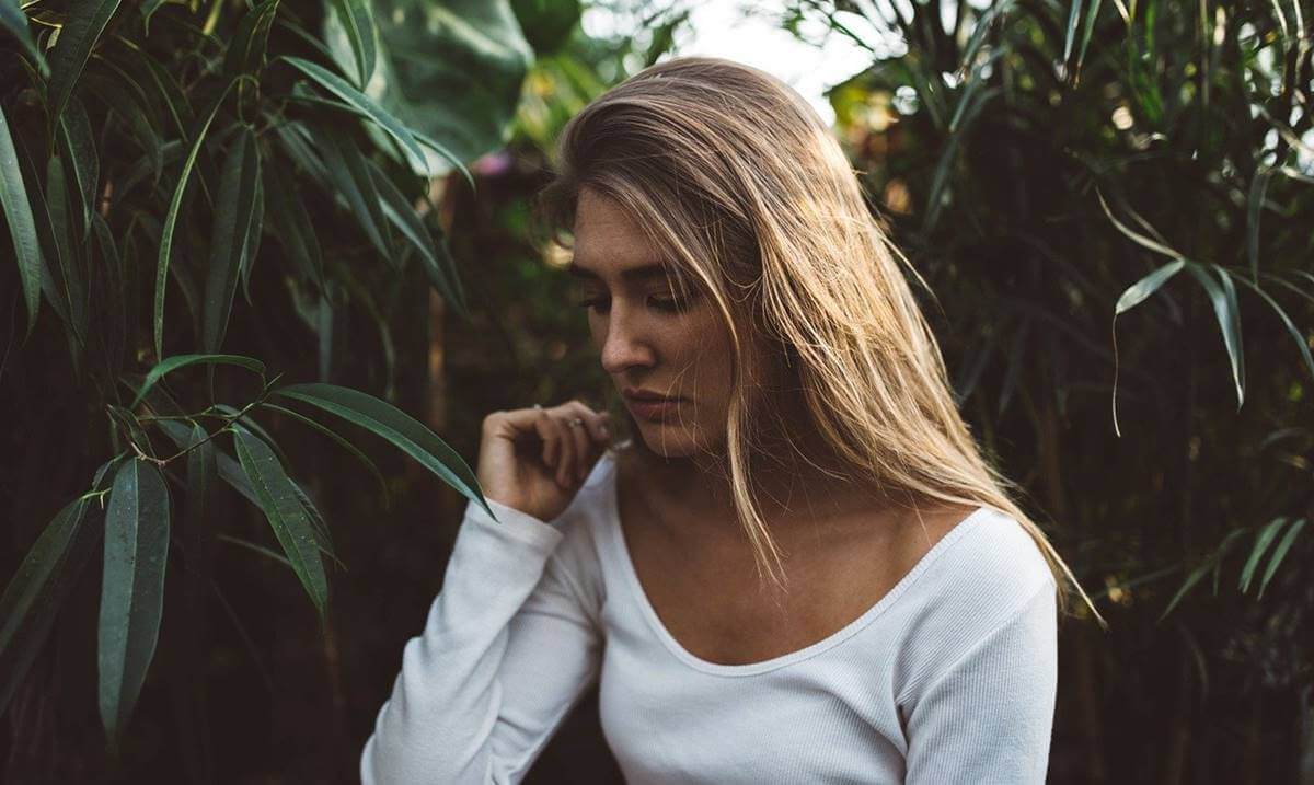 Chica triste en el campo simbolizando que la adversidad no siempre nos hace más resilientes