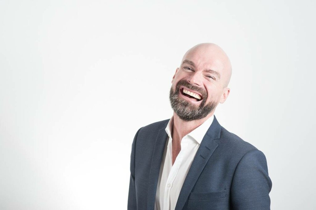 Hombre sonriendo feliz por desarrollar una personalidad más atractiva y carismática