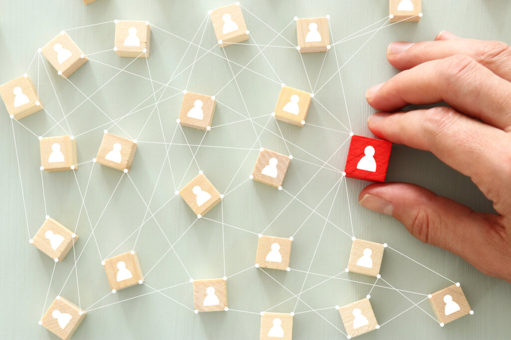 Mano cogiendo una ficha conectada con otras por hilos