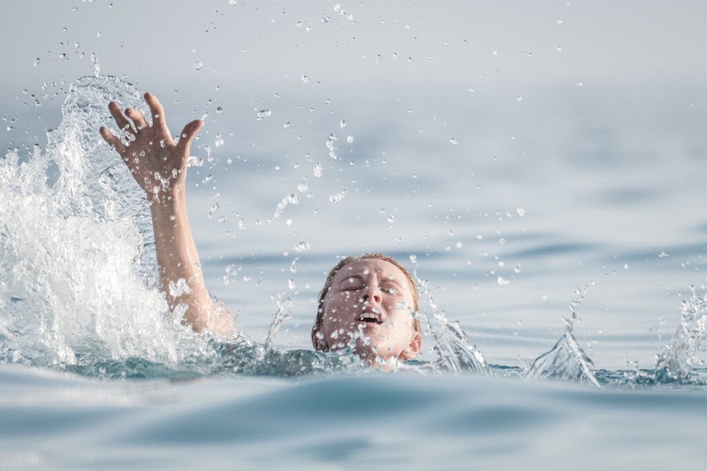 Mujer ahogándose en el mar