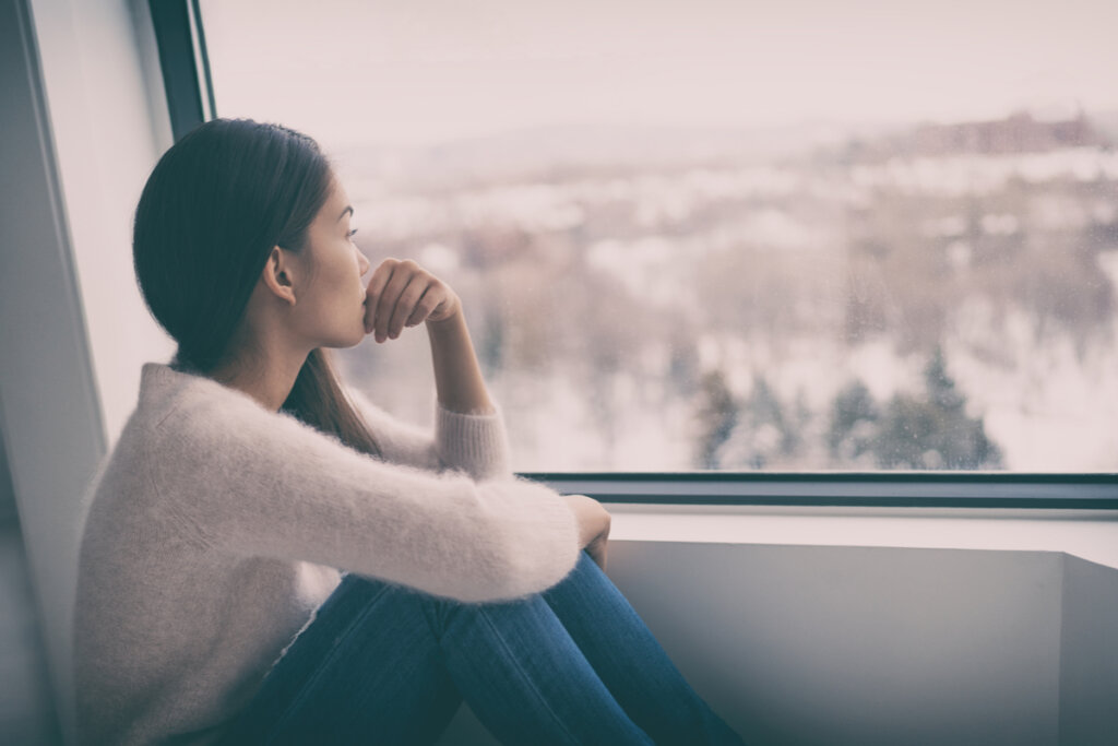 Mujer con depresión mirando por la ventana