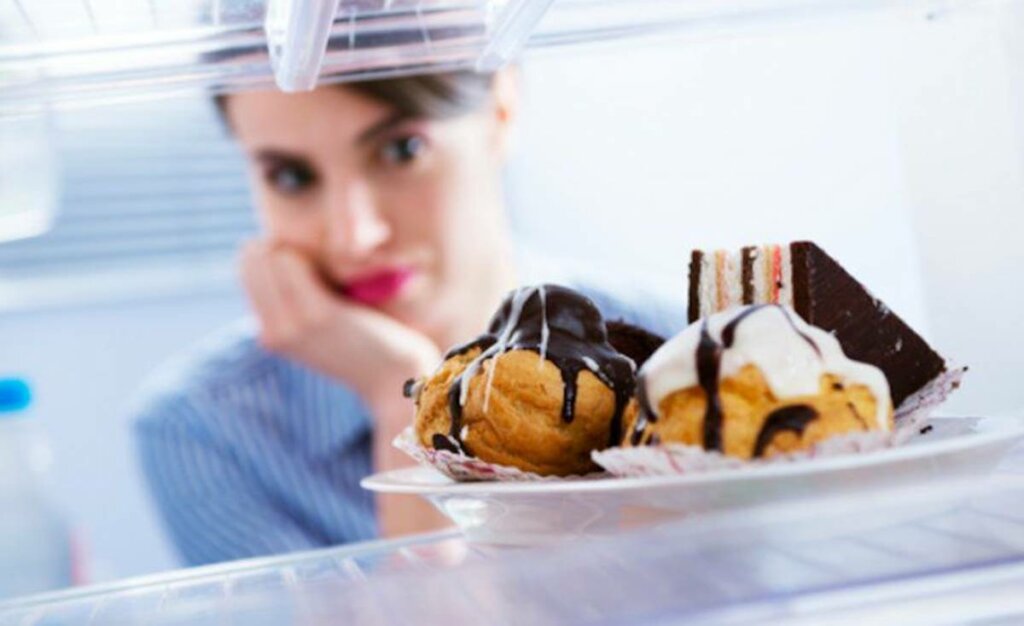 Mujer mirando dulces en la nevera