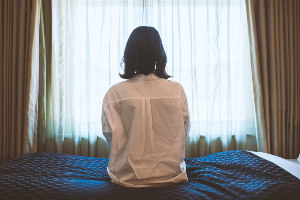 Triste femme assise sur le lit