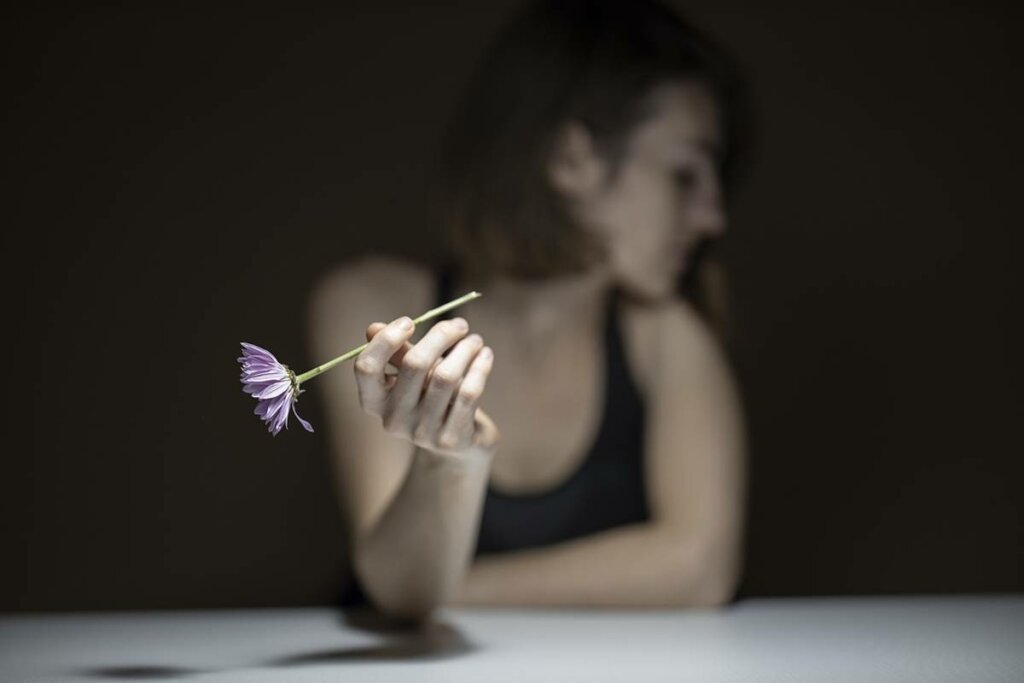Mujer sujetando una flor