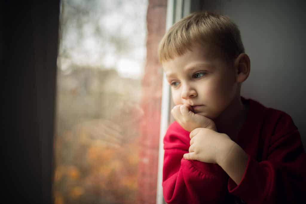 Niño preocupado en la ventana
