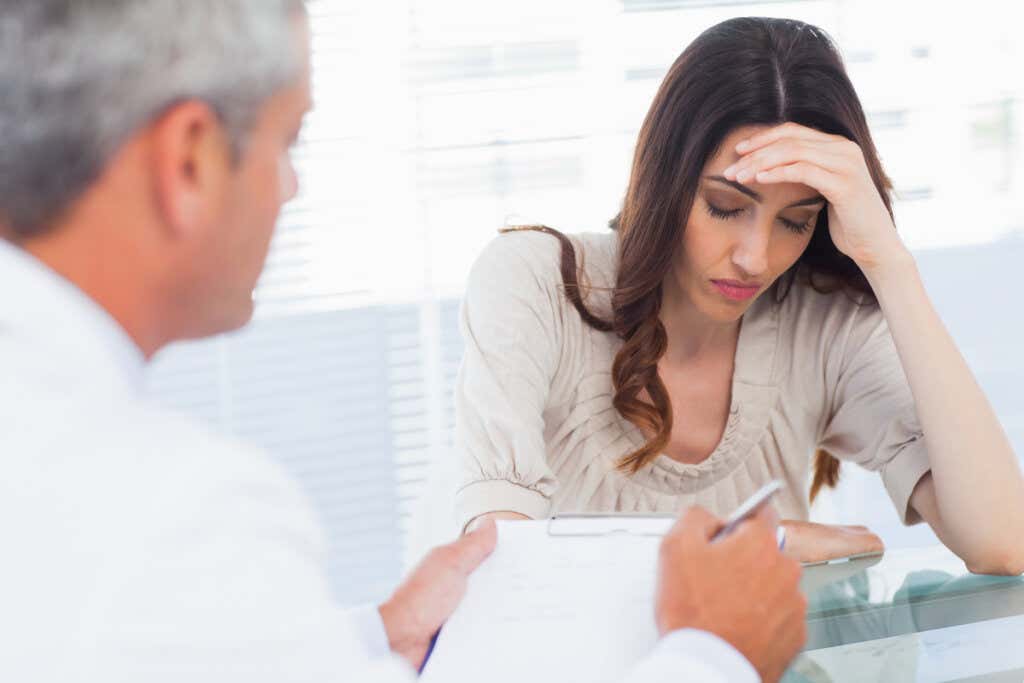 Worried patient talking to doctor symbolizing people with migraine