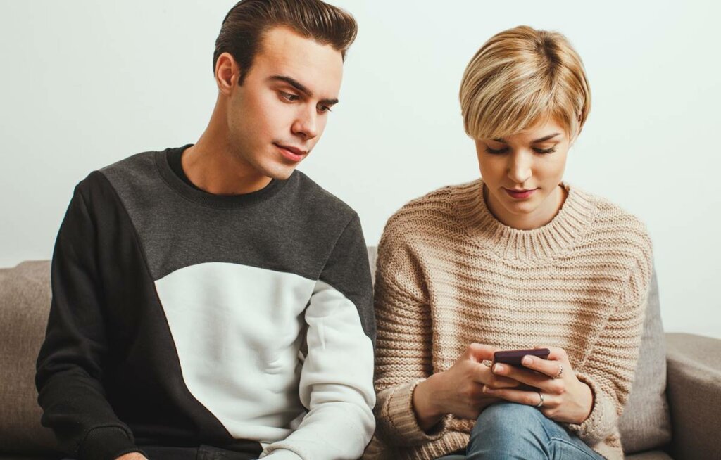 Chico espiando el móvil de su novia