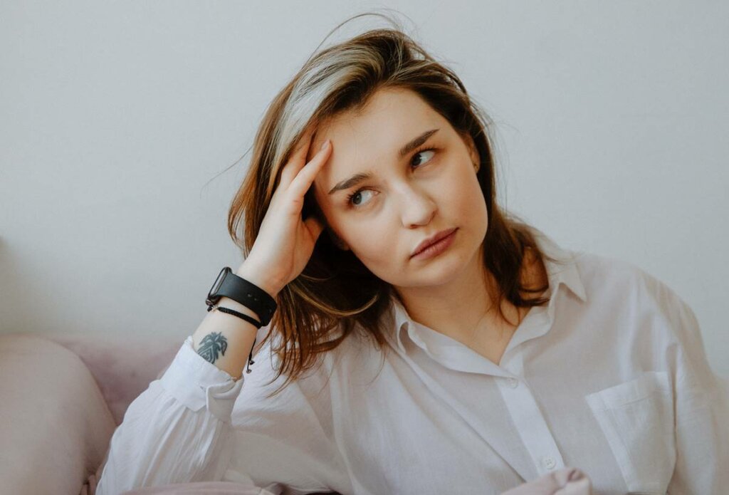 Chica con mano en la cabeza simbolizando ¿por qué estoy siempre preocupado?