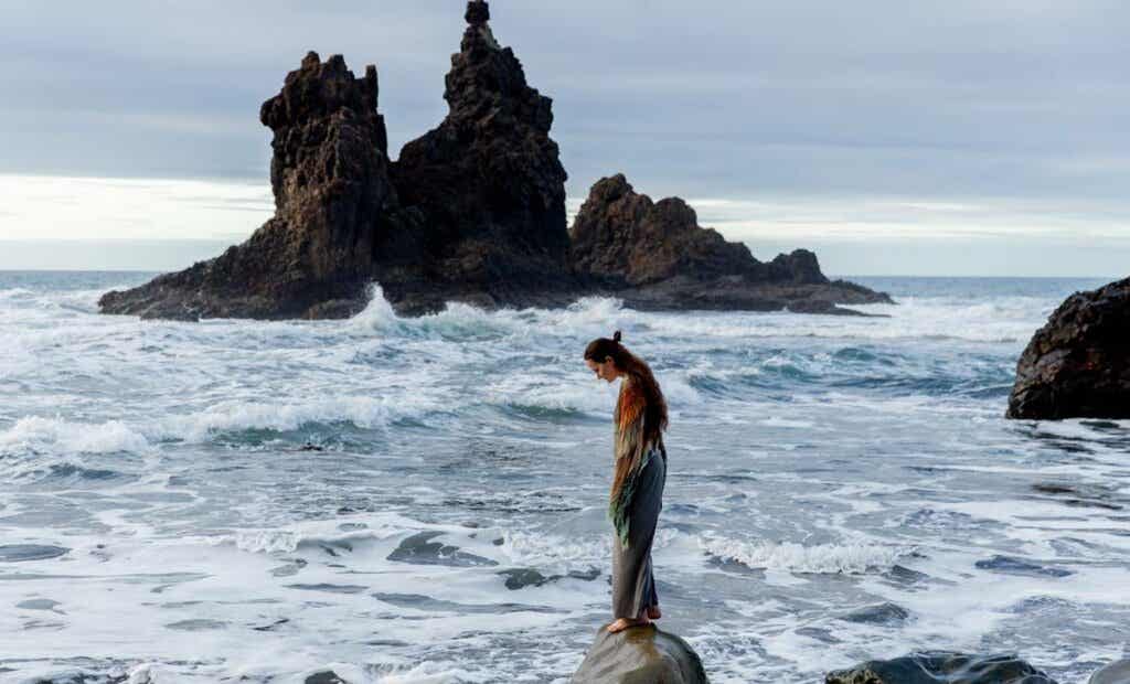 Chica en una roca sobre el mar pensando en activar la inteligencia adaptativa