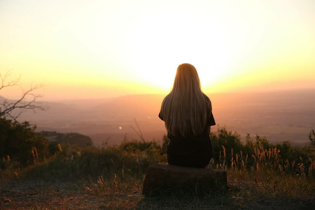 chica ante el amanecer pensando en la frases de esperanza