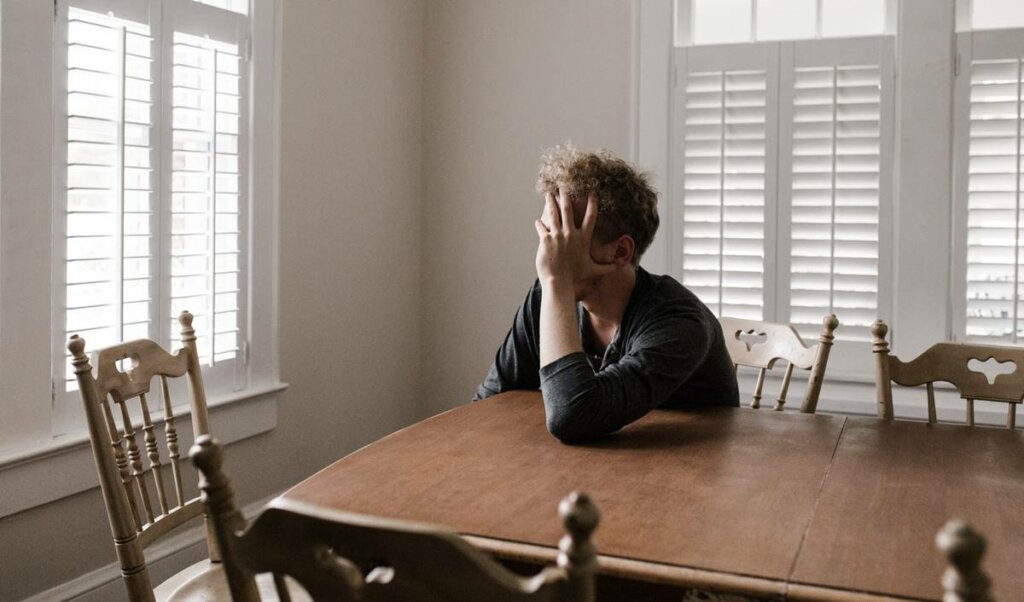 Chico agotado sobre una mesa debido a la fatiga por crisis