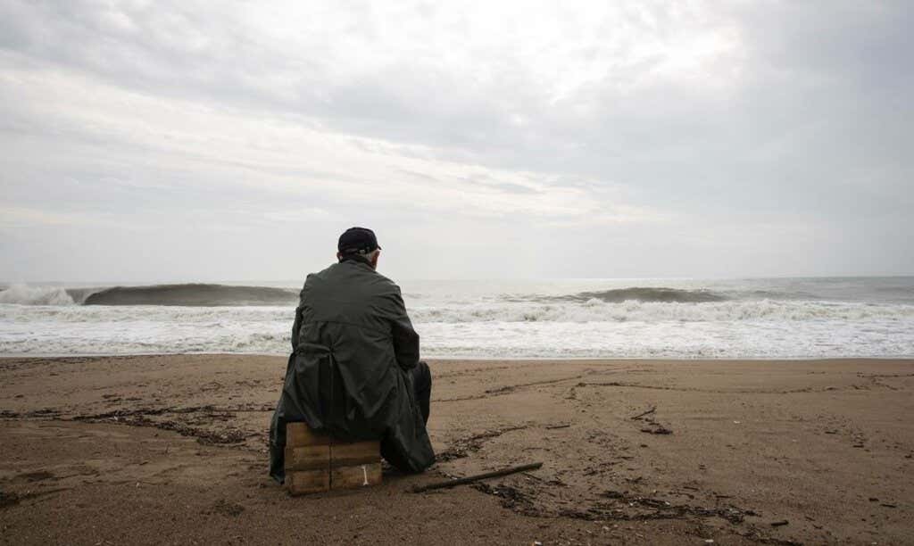 Hombre mirando el mar sobre madera pensando en el trastorno de estrés agudo