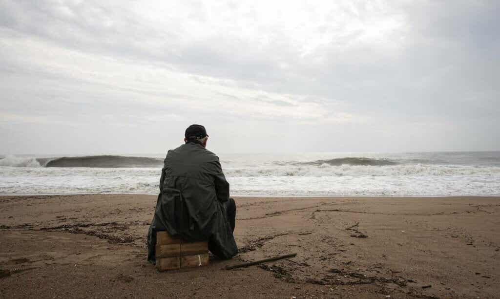 Hombre sentado mirando el mar
