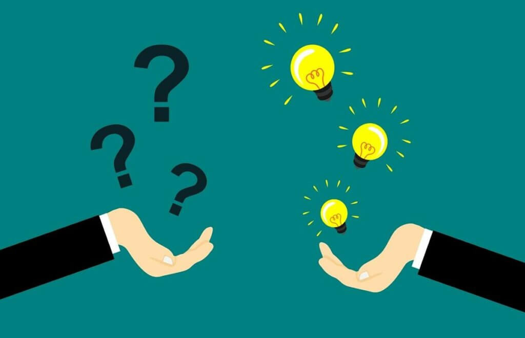 Manos con interrogaciones y bombillas