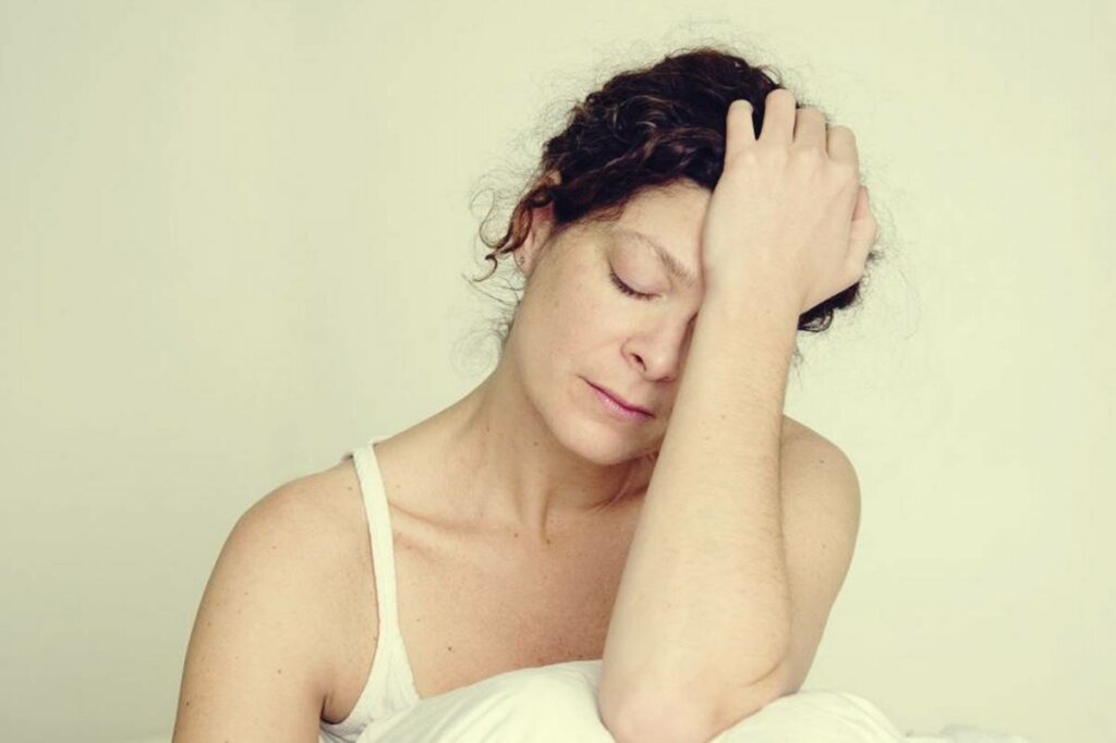 Mujer con mano en la cabeza preguntándose ¿Por qué estoy tan cansado cuando tengo ansiedad?