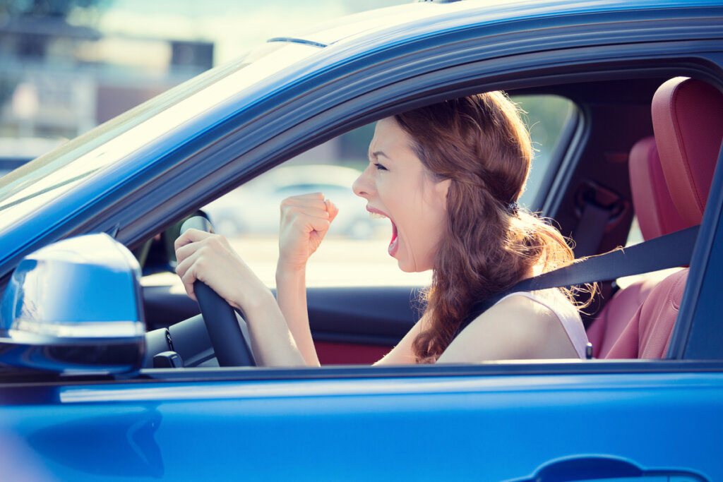 Mujer gritando en el coche por los desplazamientos de casa al trabajo