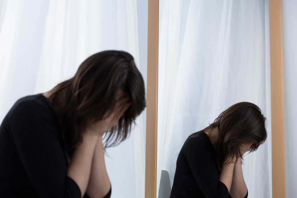 Mulher chorando na frente do espelho
