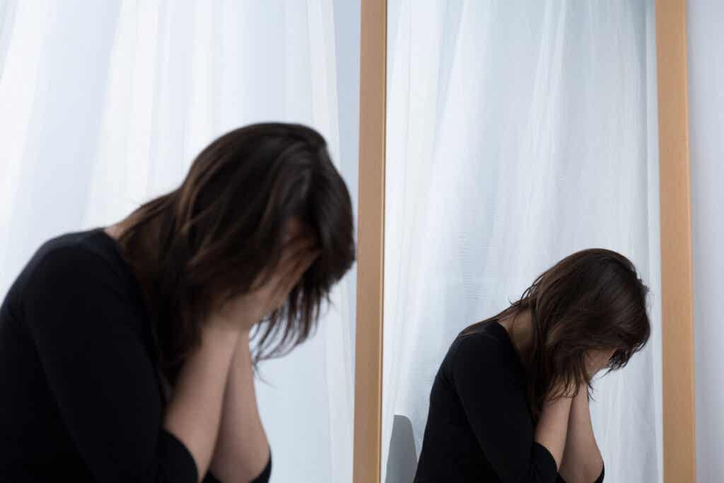 Weinende Frau vor dem Spiegel denkt an Gewichtsabnahme