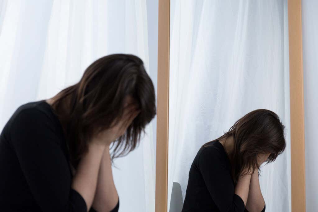 Płacząca kobieta przed lustrem
