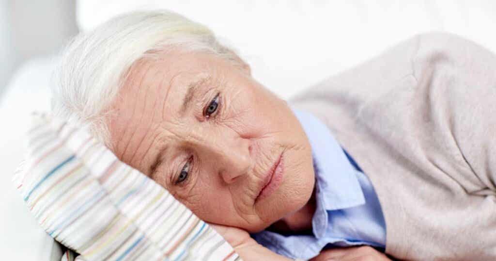 Mujer mayor acostada evidenciando bradipsiquia
