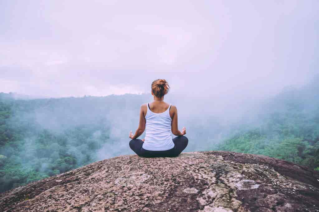 Mujer meditando y aplicando el pensamiento holístico