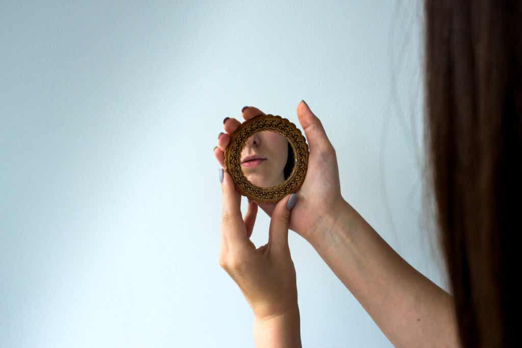Femme regardant dans le miroir symbolisant les différences entre le narcissisme et l'égocentrisme
