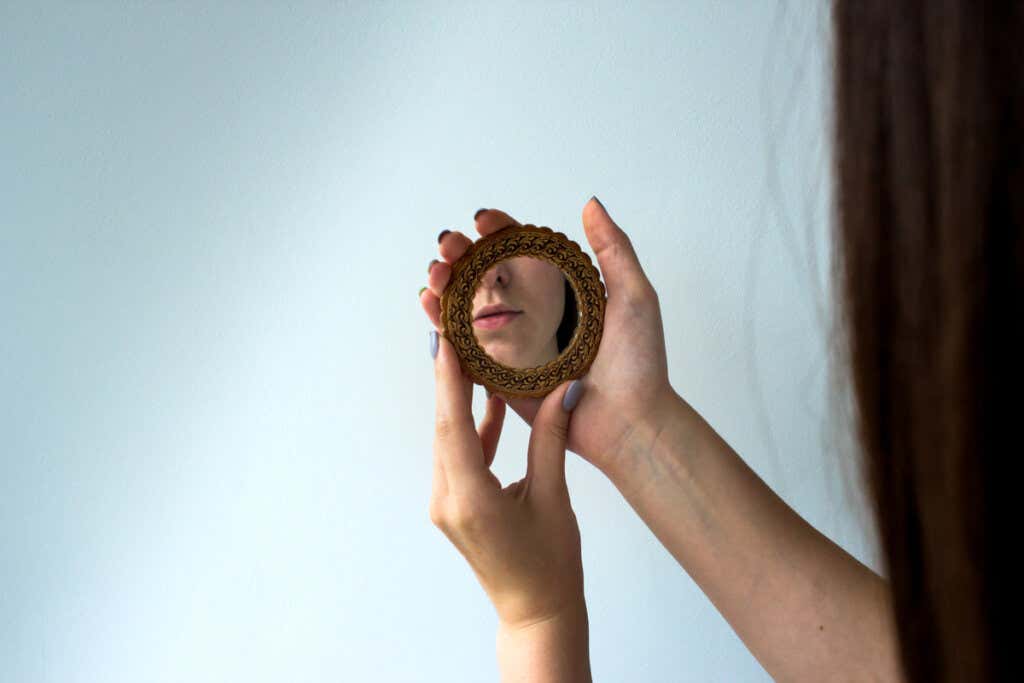 Kobieta patrząca w lustro symbolizujące różnice między narcyzmem a egocentryzmem