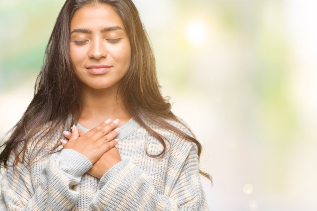 Mujer poniéndose las manos en el corazón