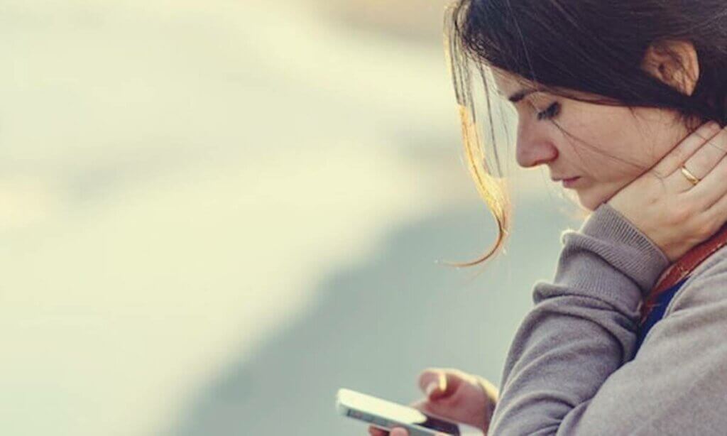 Mujer triste mirando el teléfono