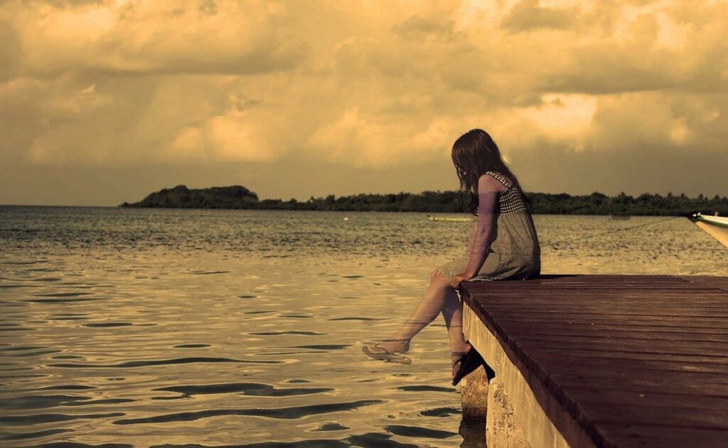 Niña sola en muelle simbolizando la herida de los padres que abandonan a los hijos