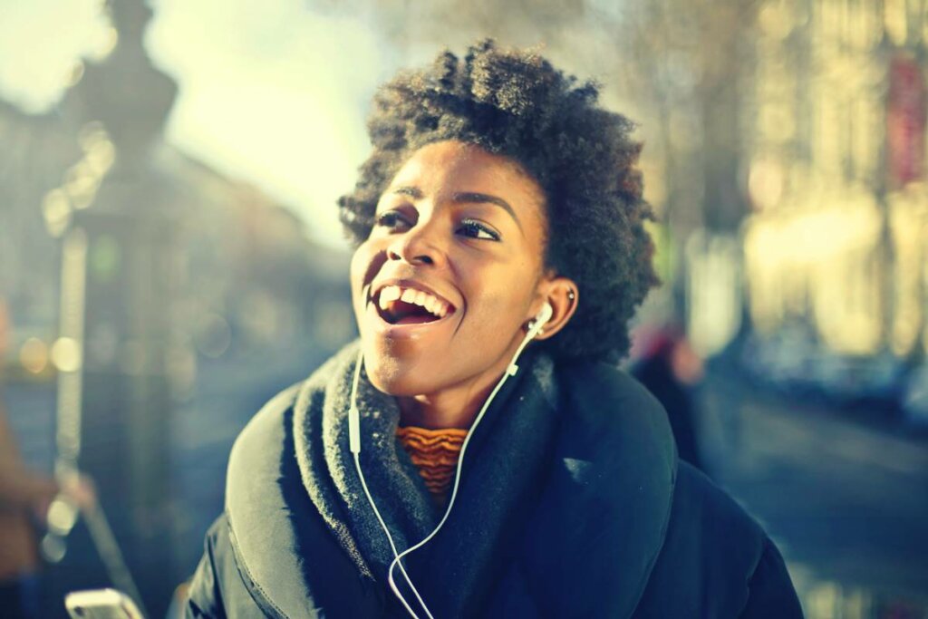 Chica feliz escuchando música en la fase de hipomanía