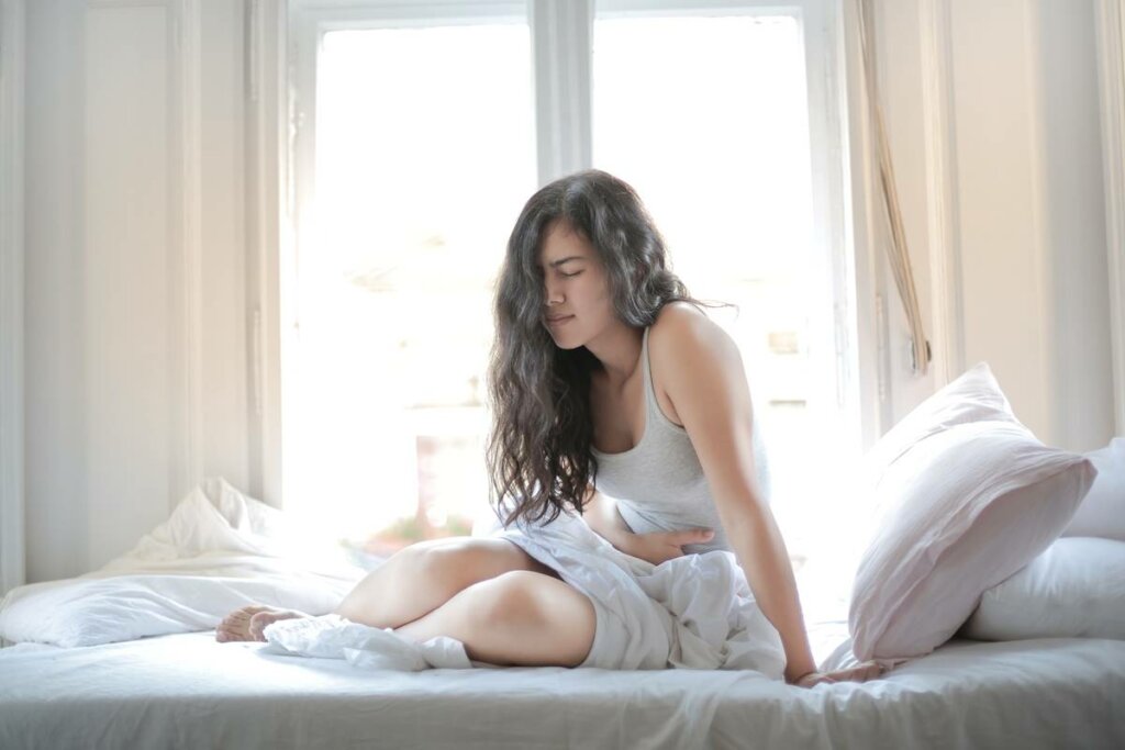 Girl in bed in pain due to illness anxiety