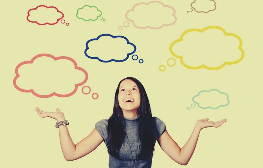 Chica con bocadillos en forma de nubes aplicando el Sesgo de retrospectiva